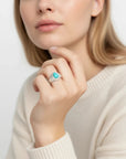 Queens Candy adjustable sterling silver ring featuring a teardrop turquoise stone and a ribbed band on a model's hand