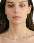 Collar choker Queens Candy Sugar Wave de cobre con baño dorado y ondas de zirconias 5A en el cuello de una modelo