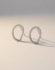 Queens Candy irregular sterling silver hugger earrings with pavé cubic zirconia stones on a neutral background