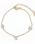 Pulsera Queens Candy de cobre bañado en oro con dijes de hamsa, estrella y símbolo chai decorados con zirconias.