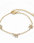 Pulsera Queens Candy de cobre bañado en oro con dijes de Hamsa y estrella decorados con brillantes cubic zirconia.