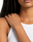 Pulsera Queens Candy Sweet Gaze de plata dorada con dije de ojo turco, zirconias azules y blancas en muñeca de mujer.