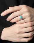 Queens Candy adjustable sterling silver heart ring with a turquoise stone and ribbed band on a woman's finger