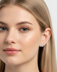 Queens Candy sterling silver stud earrings with an irregular wavy design and sparkling cubic zirconia stones on a model