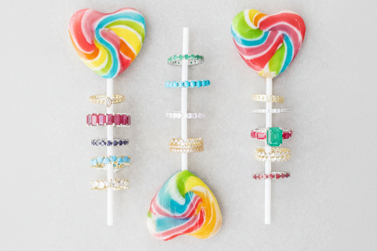 Colorful heart-shaped lollipops with rings on a gray background