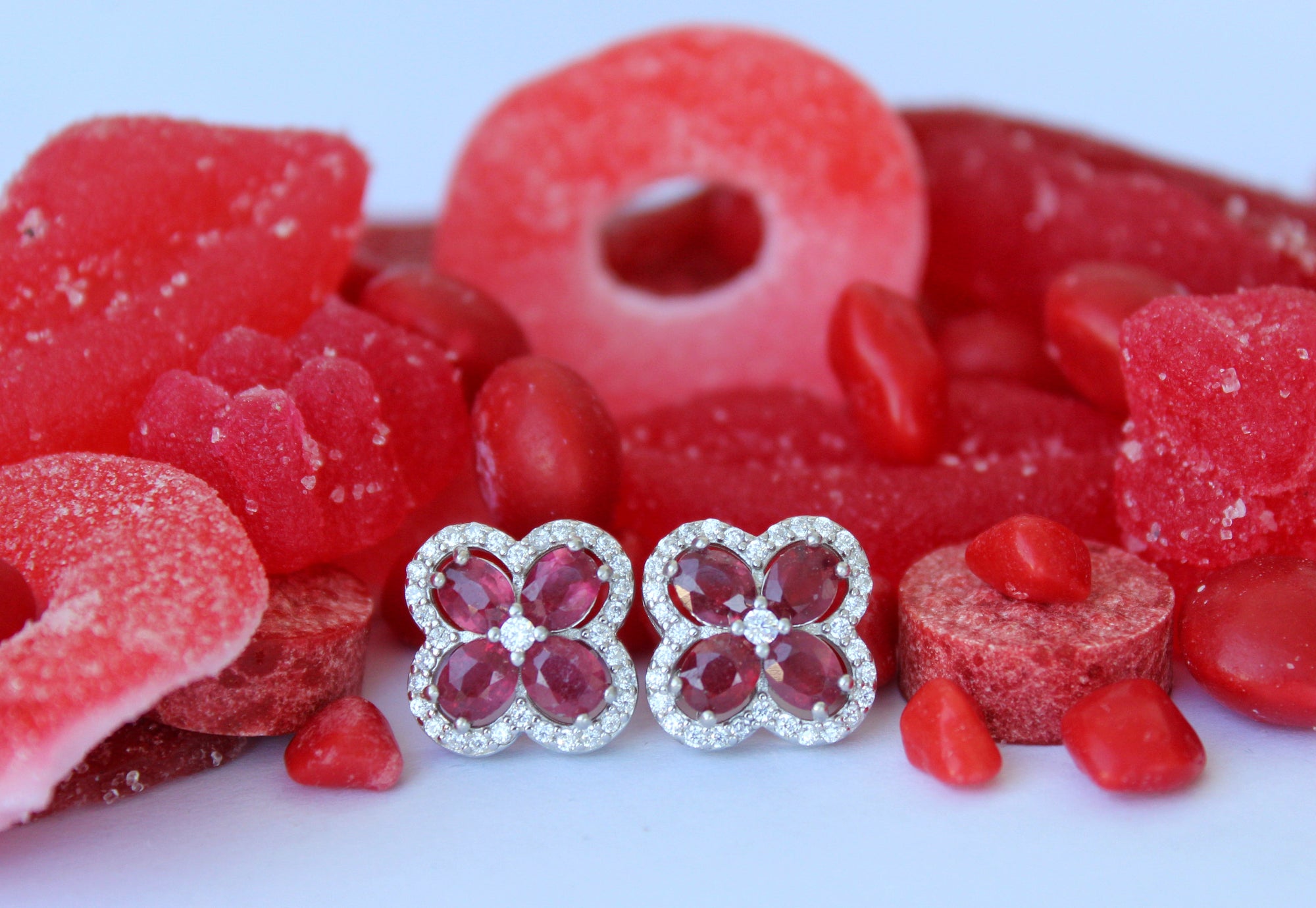 ruby flower earrings among red candies