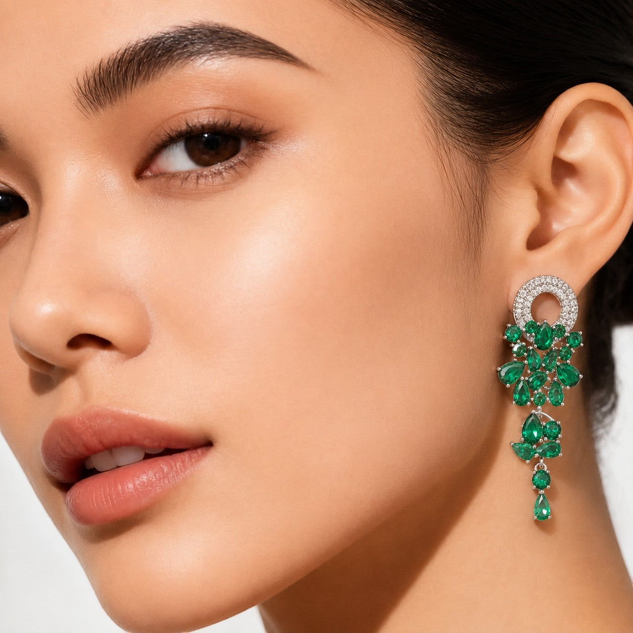 Aretes Queens Candy Sugar Cascade largos con zirconias verdes en forma de hoja y baño plateado sobre modelo