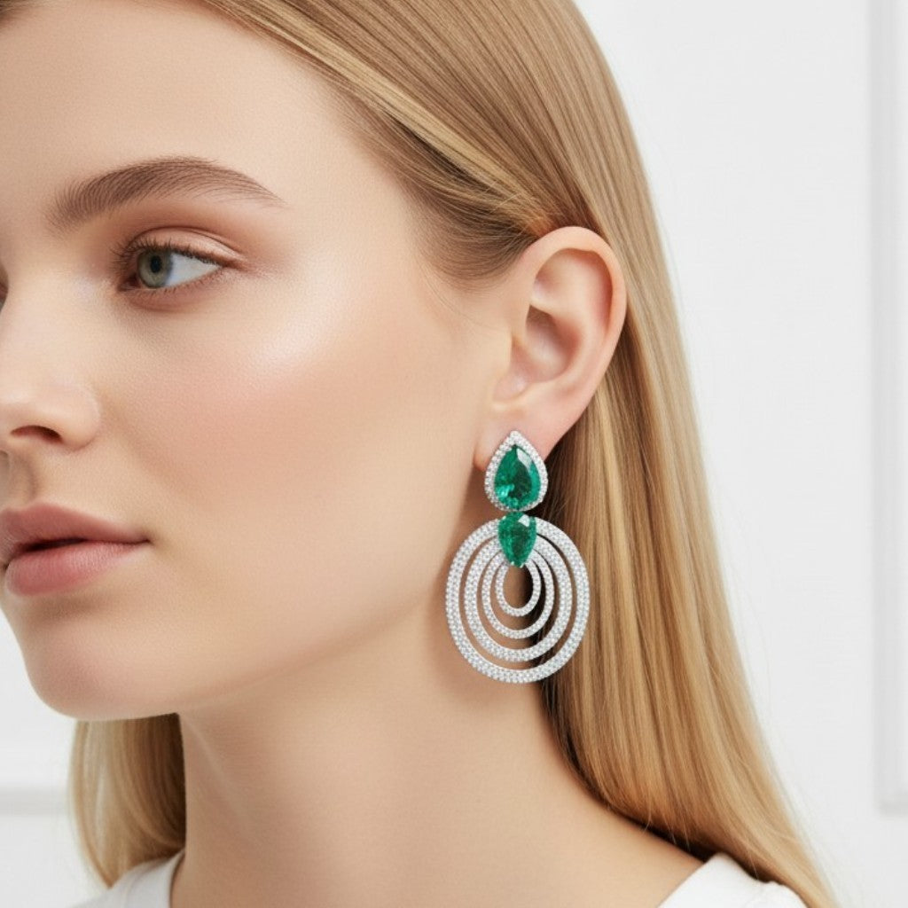 Aretes colgantes Queens Candy de latón con baño de rodio, zirconias blancas y gotas verdes tipo esmeralda.