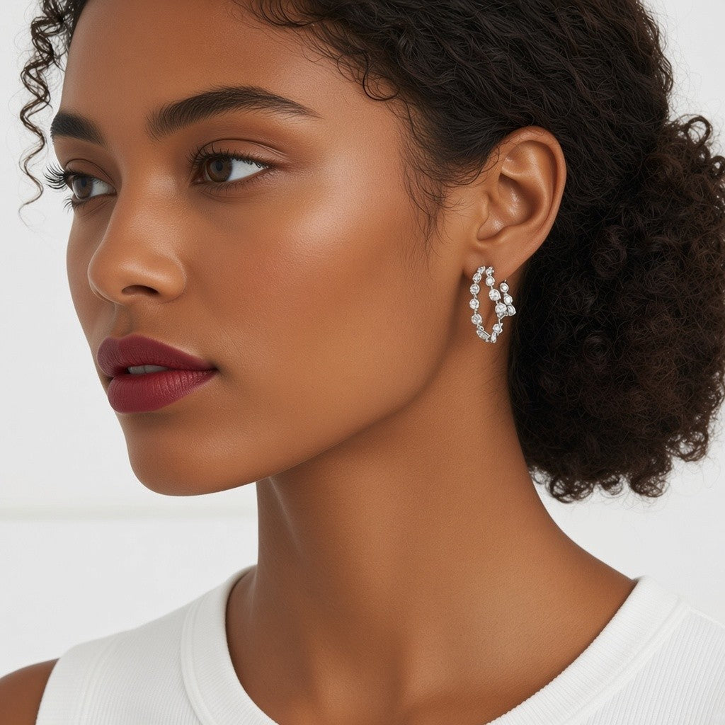 Modelo luciendo aretes Queens Candy de doble aro plateado con zirconias cúbicas brillantes en un diseño elegante