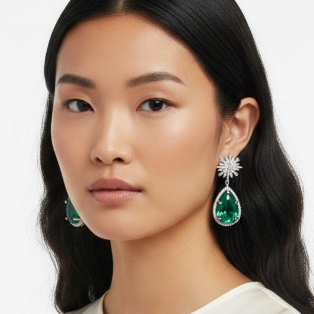 Aretes Queens Candy Bloom Drop con flor de zirconias y gota de cristal verde en baño dorado sobre modelo