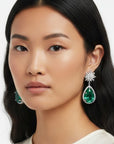 Aretes Queens Candy Bloom Drop con flor de zirconias y gota de cristal verde en baño dorado sobre modelo