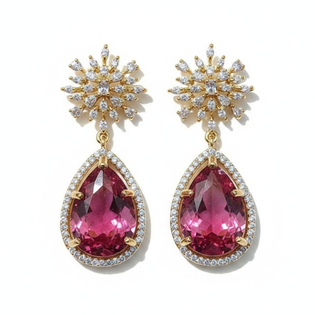 Aretes Queens Candy Bloom con top floral de zirconias y gota de cristal fucsia en cobre con baño dorado.