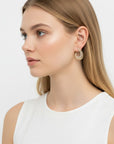 Aretes front-back Queens Candy dorados con zirconias cúbicas en diseño circular puestos en una modelo de perfil
