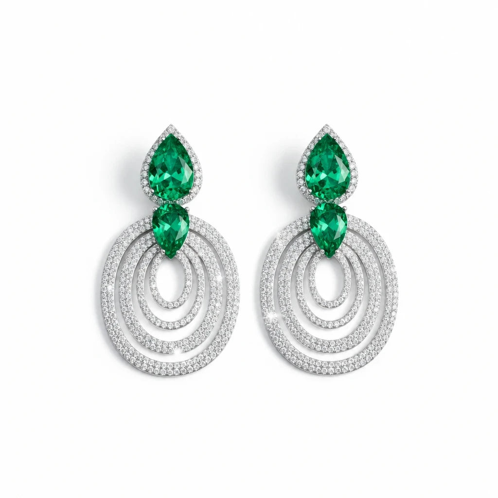 Aretes colgantes Queens Candy de latón con baño de rodio, zirconias blancas y gotas verdes tipo esmeralda.
