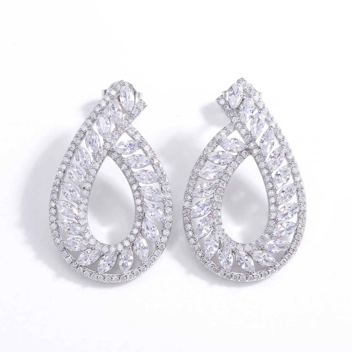 Aretes colgantes Queens Candy en forma de hoja de latón con baño de rodio y zirconias cúbicas corte marquesa.