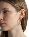 Aretes hoop Queens Candy de 26mm en cobre con baño dorado y zirconias brillantes puestos en una modelo