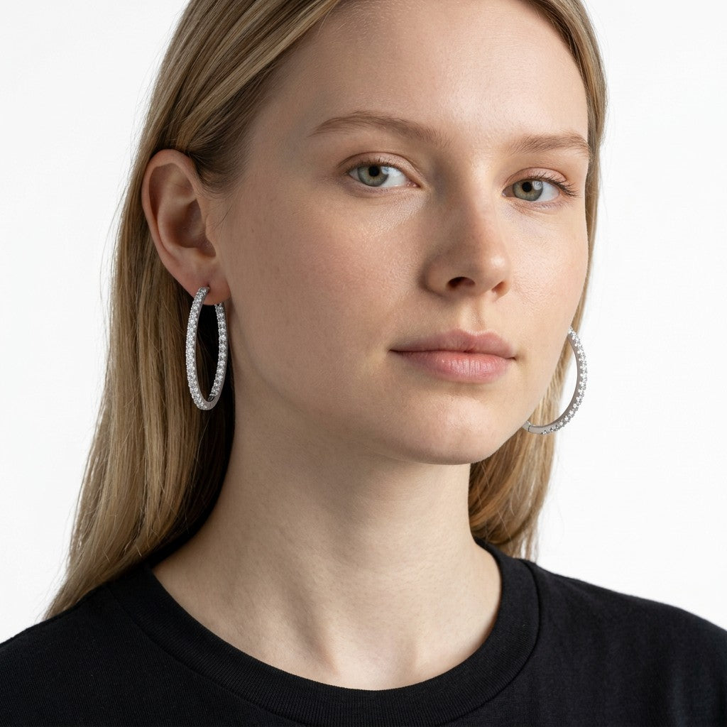 Modelo luciendo aretes hoop Queens Candy de 26mm en cobre con baño plateado y zirconias brillantes