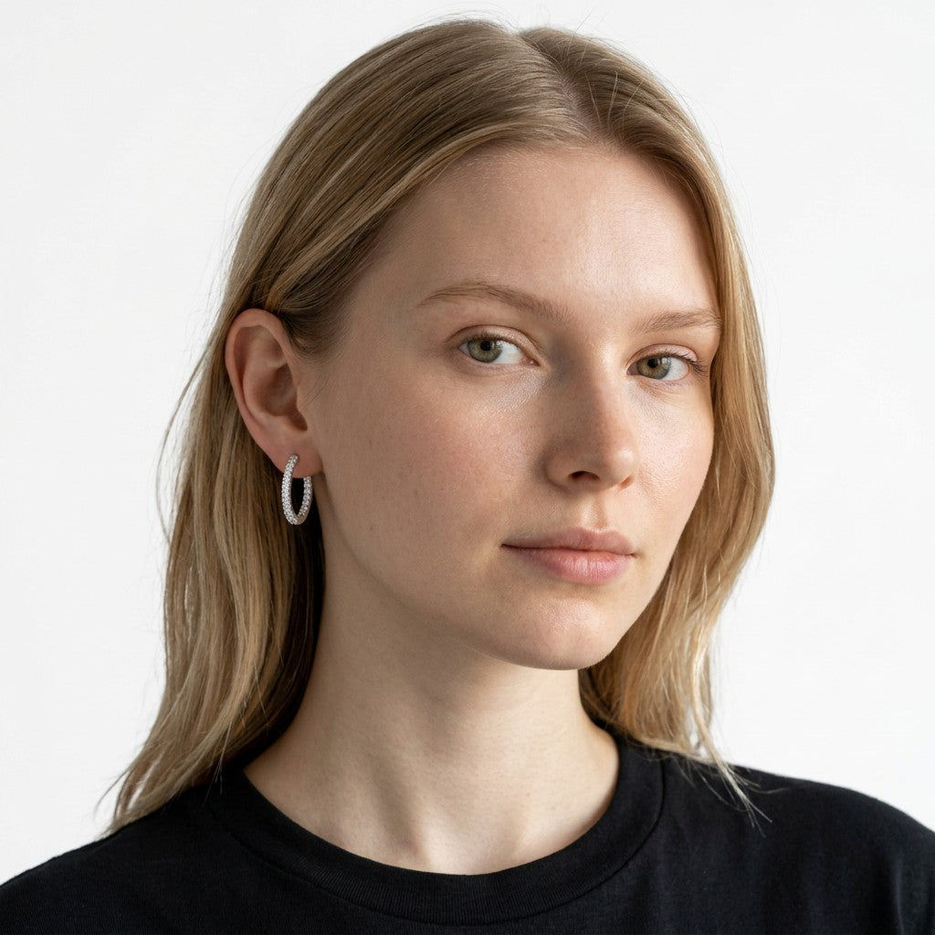 Modelo luciendo aretes hoop Queens Candy de 22mm en baño plateado con zirconias brillantes en todo el aro.