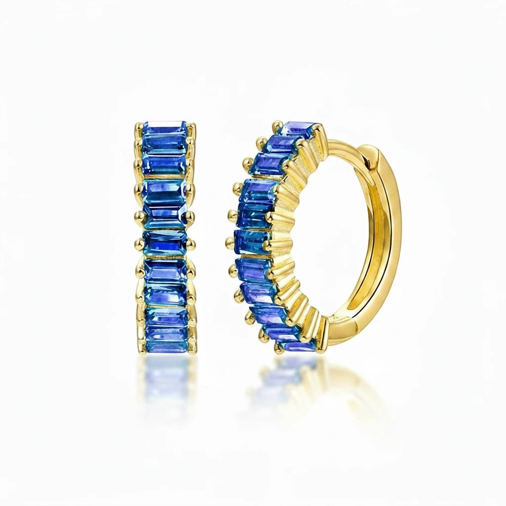 Aretes huggie Queens Candy de plata 925 con baño dorado y zirconias cúbicas azules en corte baguette