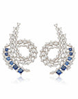 Aretes Queens Candy de cobre con baño de rodio, zirconias azules tipo zafiro y perlas simuladas en diseño espiral.