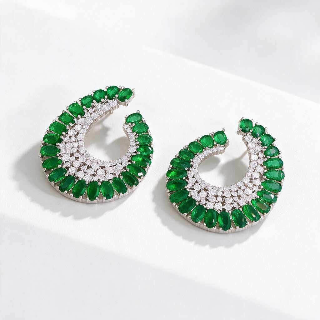 Aretes Queens Candy estilo vintage con zirconias cúbicas verdes y blancas en forma de media luna sobre base plateada.