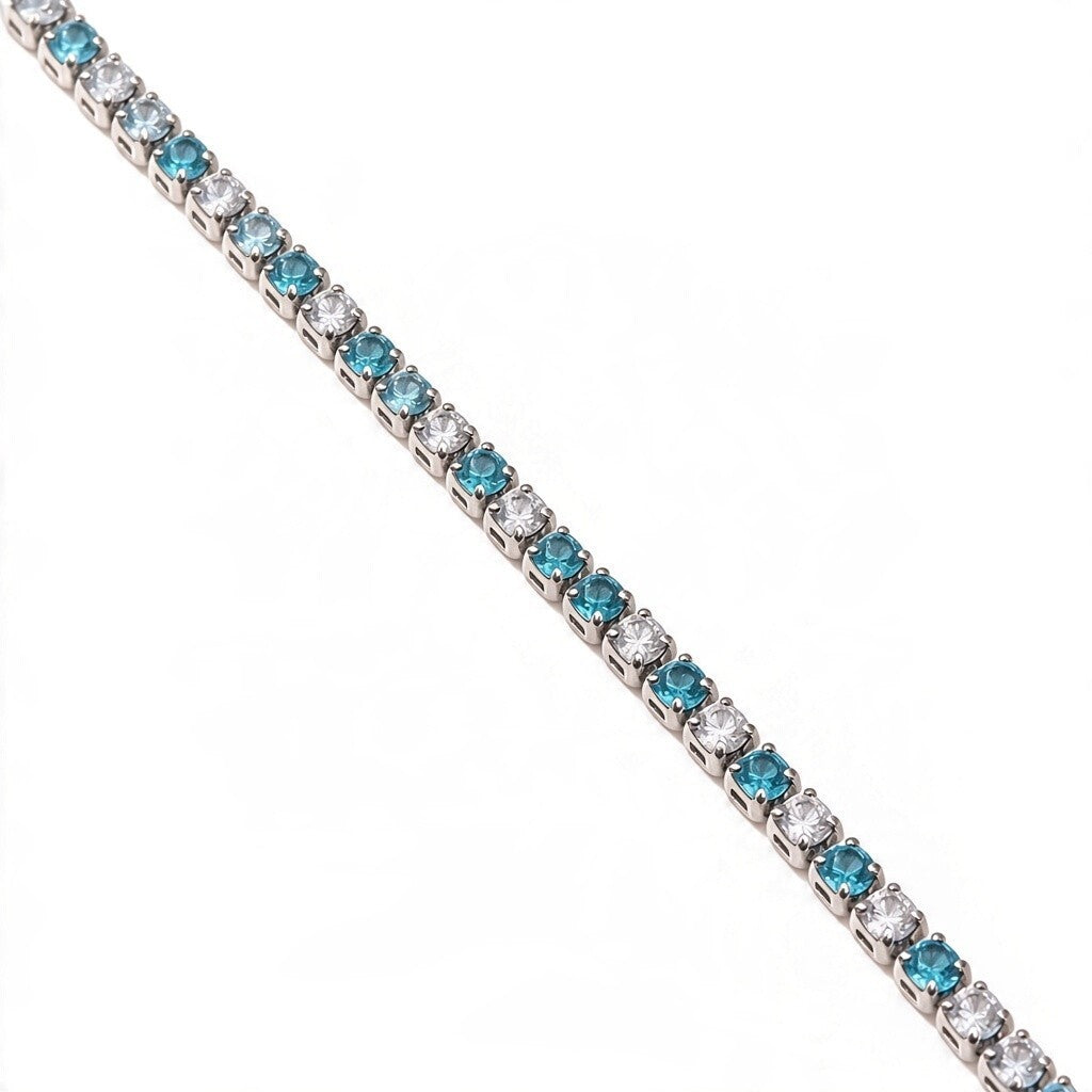 Queens Candy tennis necklace featuring alternating round-cut blue and white cubic zirconia stones in a silver setting.