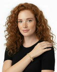 Modelo pelirroja luciendo el brazalete Queens Candy Shimmer Drip en tono rose gold con zirconias brillantes