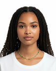 Modelo luciendo collar choker Queens Candy tipo tennis con zirconias verdes y baño dorado de 16 pulgadas