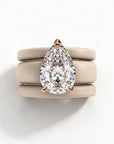 Queens Candy set of three cream silicone stackable rings with a pear-shaped cubic zirconia in a rose gold setting.