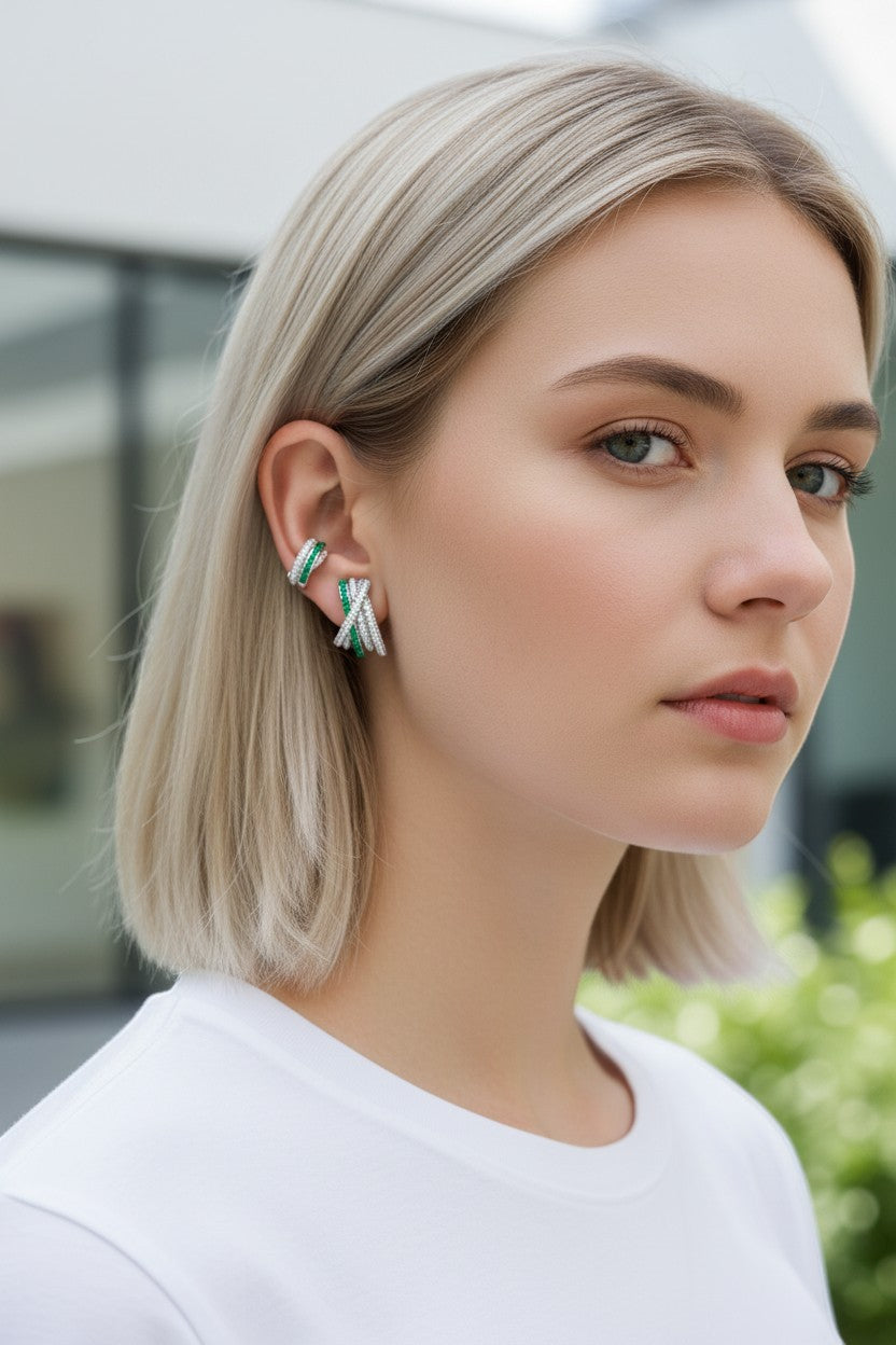 Modelo luciendo ear cuff de Queens Candy con circonitas y detalles en verde esmeralda, baño de platino sobre cobre.