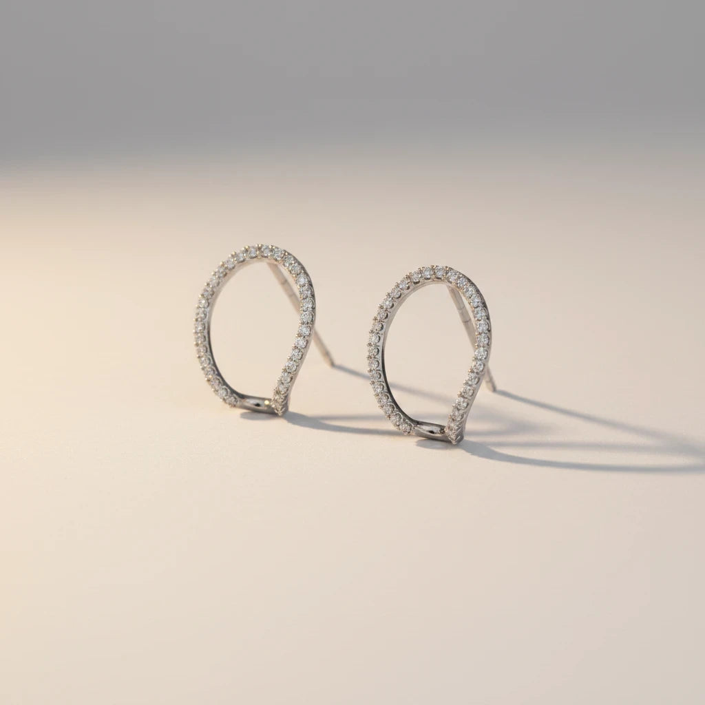 Queens Candy irregular sterling silver hugger earrings with pavé cubic zirconia stones on a neutral background