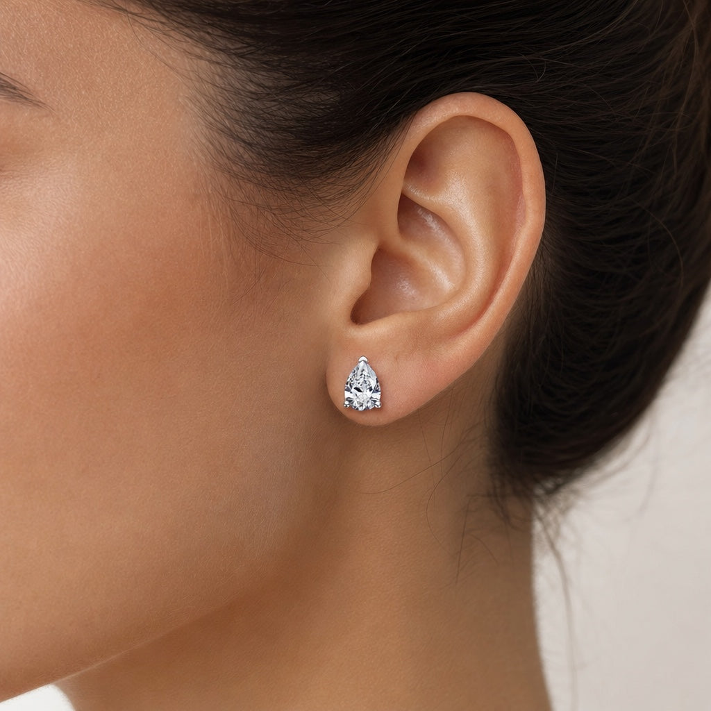 Pear Shape Moissanite Studs - puesto en modelo - Queens Candy