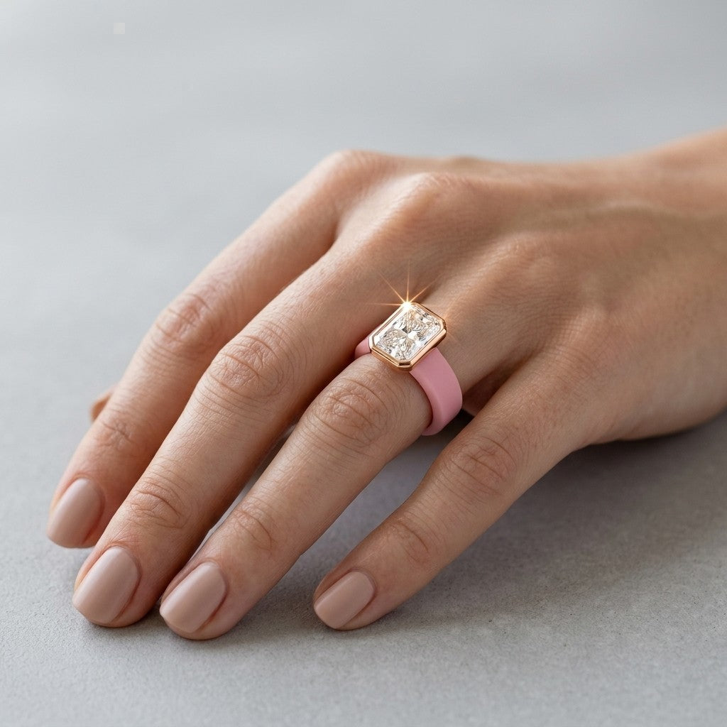Queens Candy bubblegum pink silicone ring with a rose gold bezel-set rectangular cubic zirconia on a woman's finger.