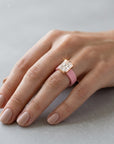 Queens Candy bubblegum pink silicone ring with a rose gold bezel-set rectangular cubic zirconia on a woman's finger.
