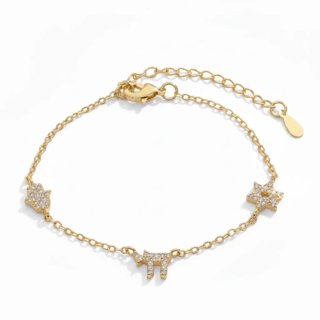 Pulsera Queens Candy de cobre bañado en oro con dijes de Hamsa y estrella decorados con brillantes cubic zirconia.
