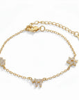 Pulsera Queens Candy de cobre bañado en oro con dijes de Hamsa y estrella decorados con brillantes cubic zirconia.