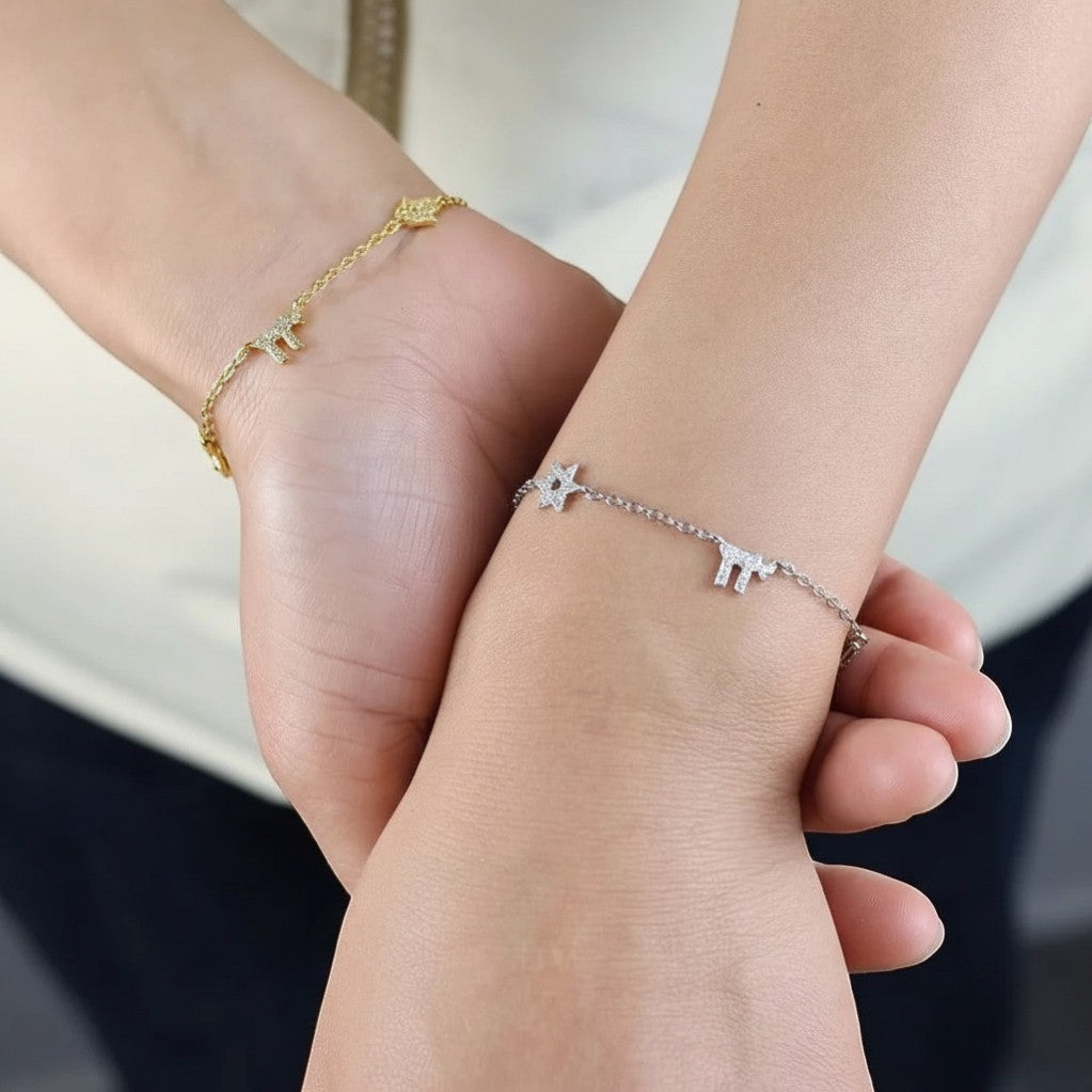 Pulsera Queens Candy plateada con dijes hamsa y zirconias brillantes en la muñeca de una mujer