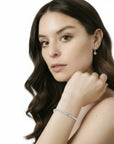 Pulsera tennis Queens Candy de cobre con baño platinum y zirconias cúbicas de 2.5mm en la muñeca de una modelo